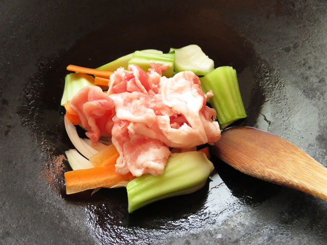 豚肉とチンゲンサイの茎部分、玉ねぎ、にんじんを中華鍋に入れる